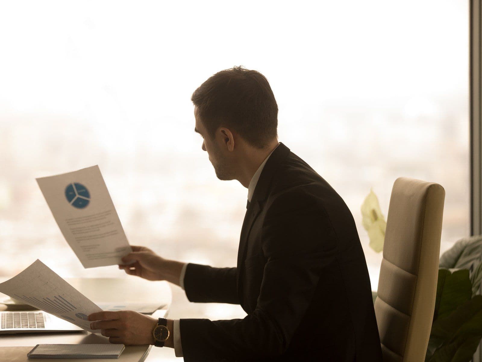 Business owner studying monthly management report figures before sending them to investors
